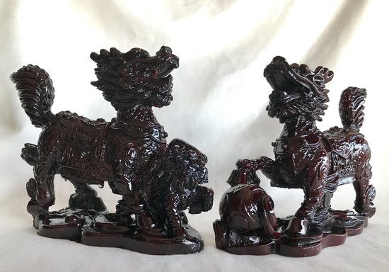 Twee bruinrode Chi Lin beelden; een met een bal, de ander met een jong, op een golvende voet.