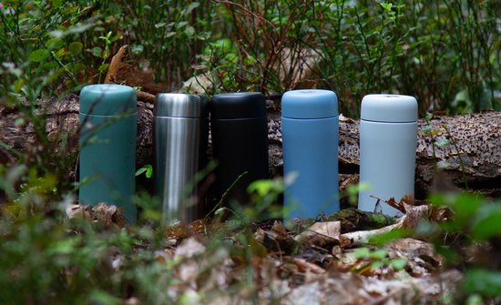 Vijf RETULP tumblers in groen, zilver, zwart, blauw en lichtgrijs in het bos.