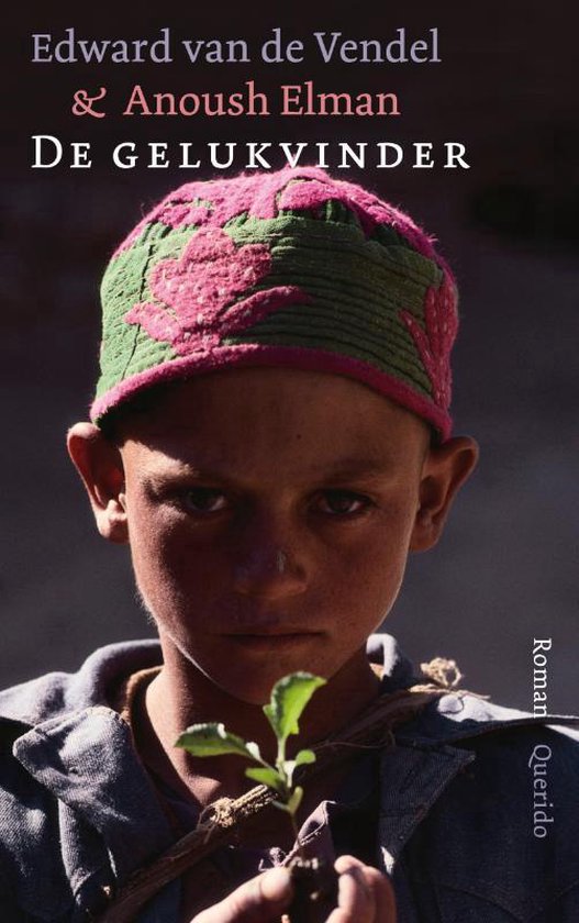 Jonge jongen met een gebreide muts met roze bloemenprint. Hij houdt een klein plantje vast.