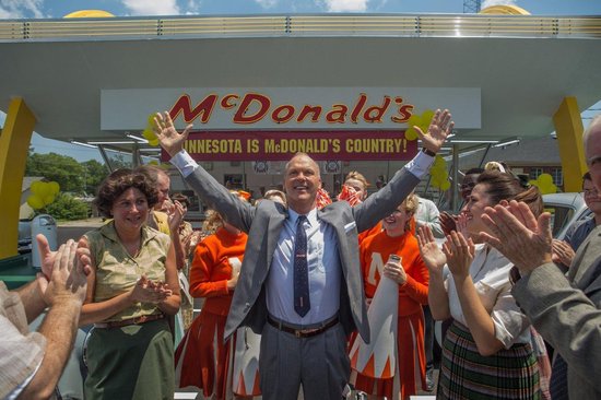 Man met armen omhoog, omringd door juichende mensen en meisjes in oranje McDonald's uniformen. Minnesota is McDonald's Land.