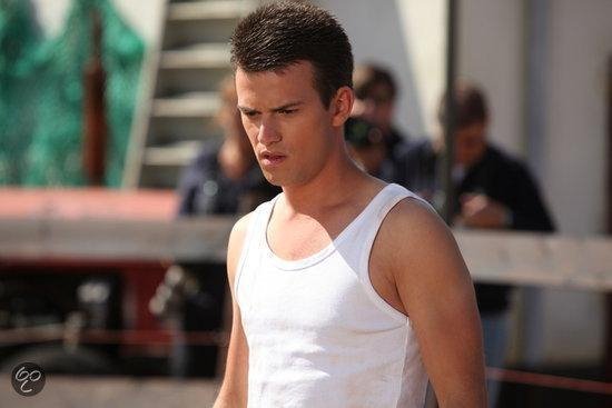 Jonge man met kort bruin haar, draagt een witte tanktop.