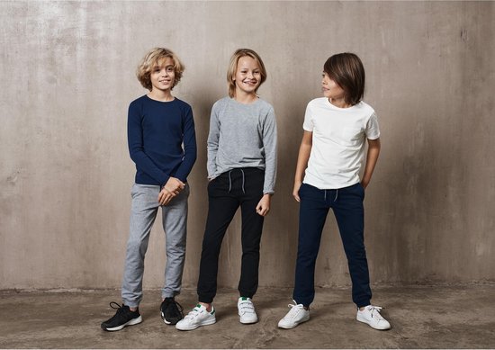 Drie jongens staan naast elkaar. De linker draagt een donkerblauwe ribbel top met grijze joggingbroek. De middelste een grijze top met zwarte joggingbroek. De rechter een witte top met donkerblauwe joggingbroek.