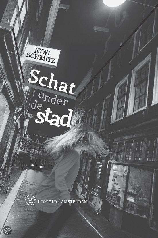 Boekcover van 'Schat onder de stad' met een vrouw met lang blond haar die wegrent op een straat 's nachts, boven de tekst 'Jowi Schmitz Schat onder de stad Leopold Amsterdam'.