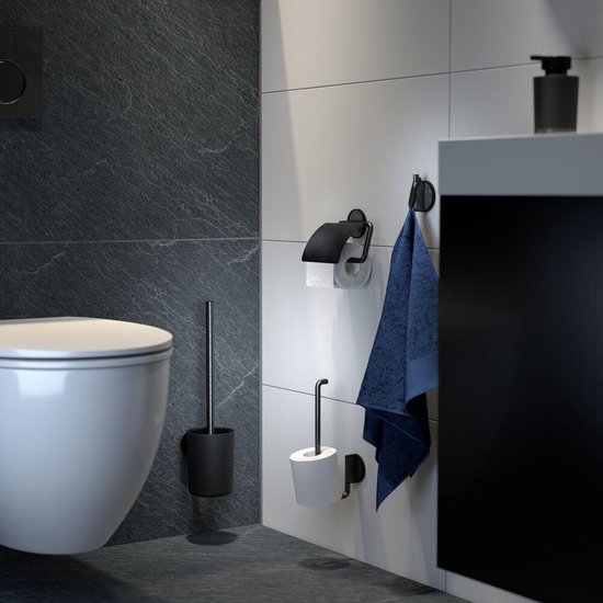 Porte-rouleau de toilette noir, brosse de toilette et crochet porte-serviettes à côté des toilettes et du lavabo.