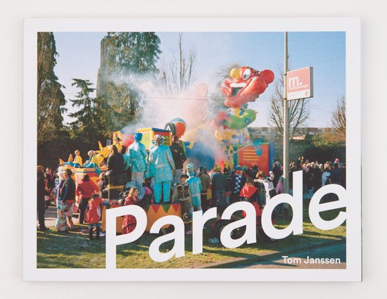 Parade met grote tijger-opblaasfiguur en mensen in kleurrijke kleding.