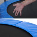 Hand op het net van de trampoline, blauwe rand van de trampoline.