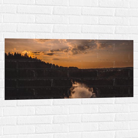 WallClassics - Muursticker - Rivier tussen de Bossen met Zonsondergang - 100x50 cm Foto op Muursticker
