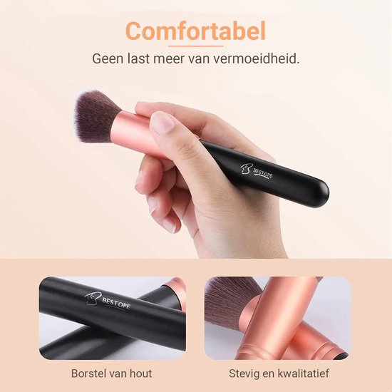 Hand houdt een rosé gouden make-up kwast vast. Close-up van een rosé gouden kwast met zwarte handvat.