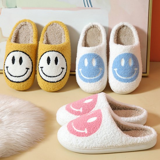 Gele, witte en roze fluffy pantoffels met smiley gezichtjes.