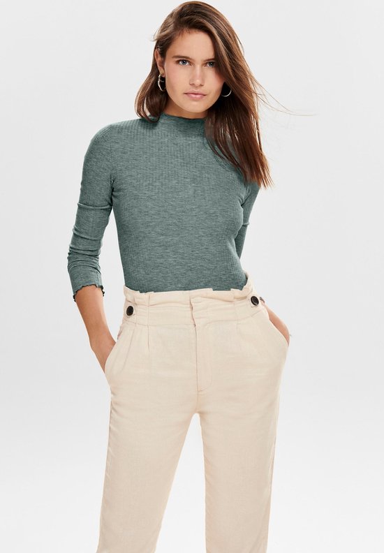 Groene coltrui met lange mouwen, gedragen door een vrouw met een beige broek met hoge taille en knopen.
