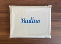Witte verpakking met het blauwe Budino logo op de voorkant.