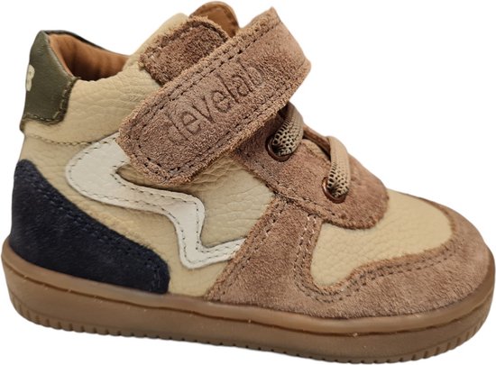 Beige leren sneaker met taupe suède, witte bogen, donkerblauwe suède en klittenbandsluiting.