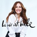 Actrice Julia Roberts lacht in witte blouse. 'La vie est belle' in kalligrafie.