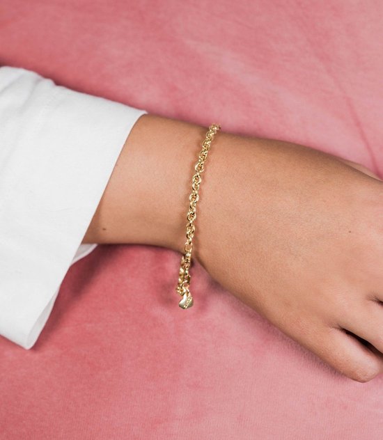 Gouden schakelarmband met hartvormig ZINZI hangertje gedragen om een pols.