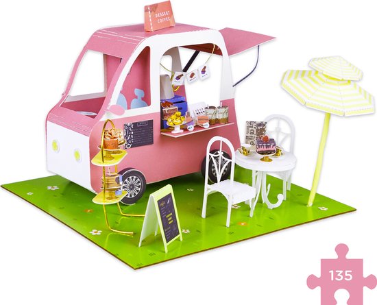 Roze en wit miniatuur foodtruck-model met gebakjes en een parasol.
