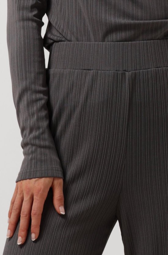 Détail de la ceinture d'un pantalon côtelé gris foncé porté par un mannequin.