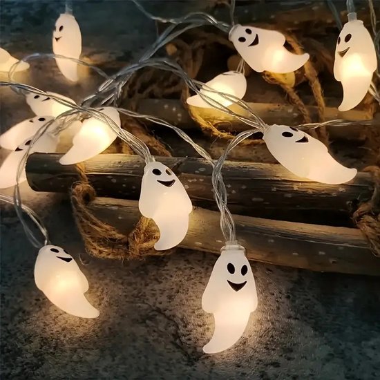 Slinger met witte spooklampjes met gezichtjes op een rustieke achtergrond.