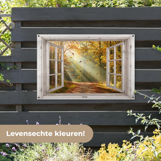 Een open houten raam met uitzicht op een bosweg met herfstbladeren, hangend aan een donkergrijze schutting.