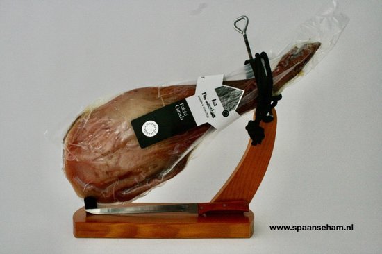Een Paleta Curada ham in plastic verpakt op een houten standaard met mes.
