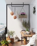 Gedecoreerd balkon met hangende bloemen, planten, een tafel en stoelen.