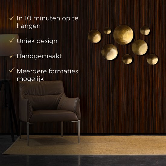 Une décoration murale dorée de huit coupelles sur un mur en bois brun, à côté d'un fauteuil en cuir.