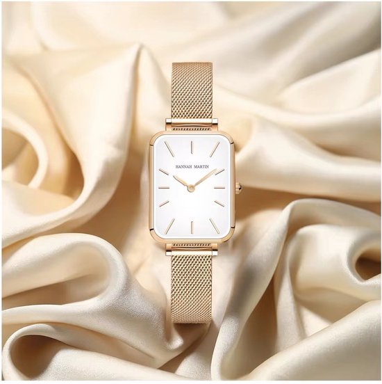 Montre carrée dorée avec bracelet en maille, présentée sur un tissu satiné crème.