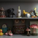 Babyfoon op een plank tussen kinderspeelgoed. Crèmekleurig met lichtgroene antenne en basis.