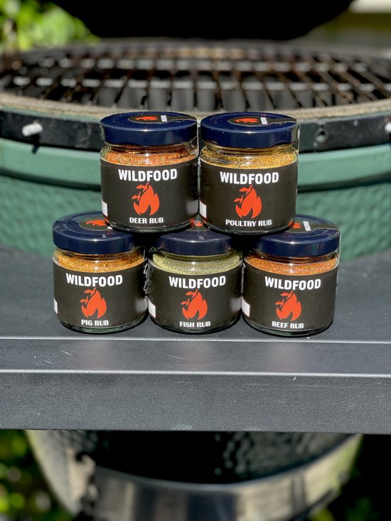 Vijf potjes Wildfood kruidenmix gestapeld voor een barbecue.