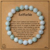 Armband van lichtgroene en witte jade kralen gerangschikt rond een kaartje met de tekst 'Zelfliefde'.