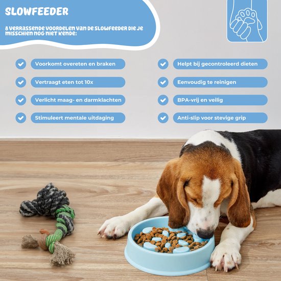 Een beagle hond eet uit een blauwe slowfeeder voerbak naast een touw speeltje.