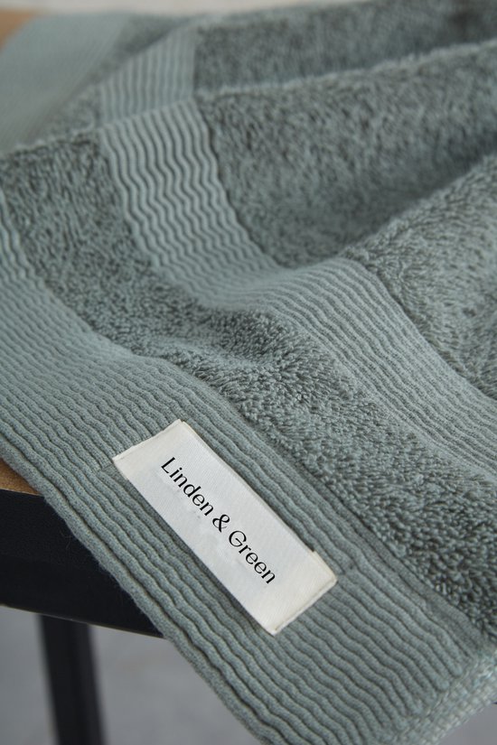 Lichtgroene handdoek met een label van Linden & Green. Geribbelde rand en zacht, absorberend materiaal.