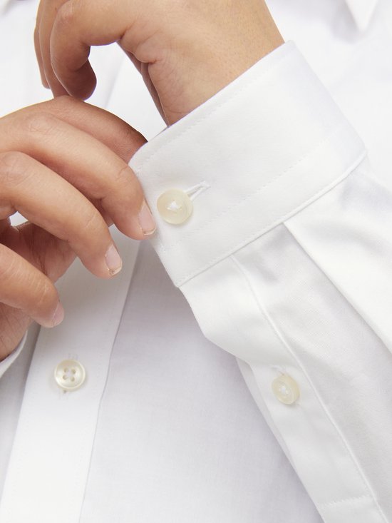 Chemise blanche en coton avec boutons blancs sur les poignets.
