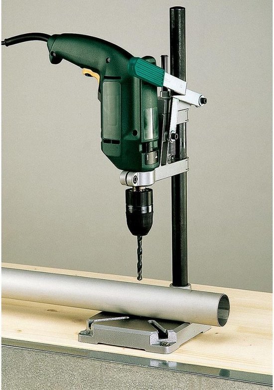 Groene boormachine op een boorstandaard met een werkstukklemming, een metalen buis.