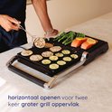Man grilt plakjes aubergine en courgette, zalm en broccoli op een Safecourt contactgrill. De grill kan horizontaal openen.