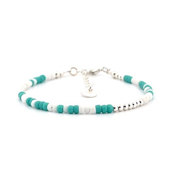 Een armband van kleine witte en turquoise kralen met zilverkleurige kralen, op een witte achtergrond.