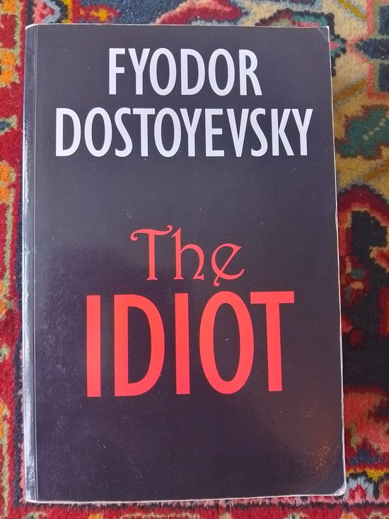 De kaft van 'The Idiot' van Fyodor Dostojevsky, met de titel in rode letters op een zwarte achtergrond.