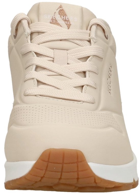 Baskets Skechers beiges à lacets, semelle blanche et détails cuivrés.