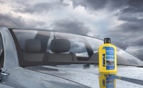 Gele fles Rain-X Anti-Pluie/Anti-Regen op de motorkap van een auto, regenachtig weer.
