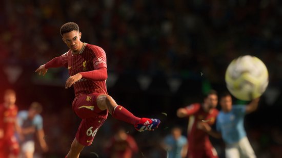 Footballspeler in rood Liverpool tenue schiet op de bal, in een vol stadion.