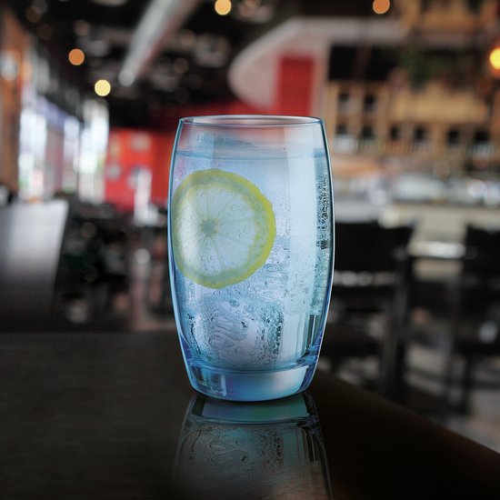 Een blauw glas met bruisend water, ijsblokjes en een schijfje citroen.
