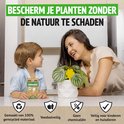 Een vrouw en een jong kind kijken elkaar lachend aan bij een kamerplant met een gele, bloemvormige vliegenvanger. Op tafel staat de verpakking van de vliegenvangers.