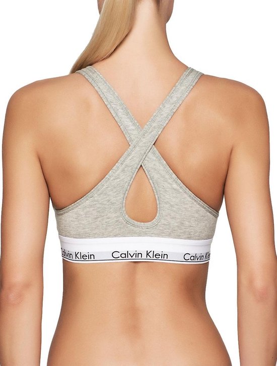 Grijze Calvin Klein bralette, achterkant met gekruiste bandjes en wit logo-elastiek.