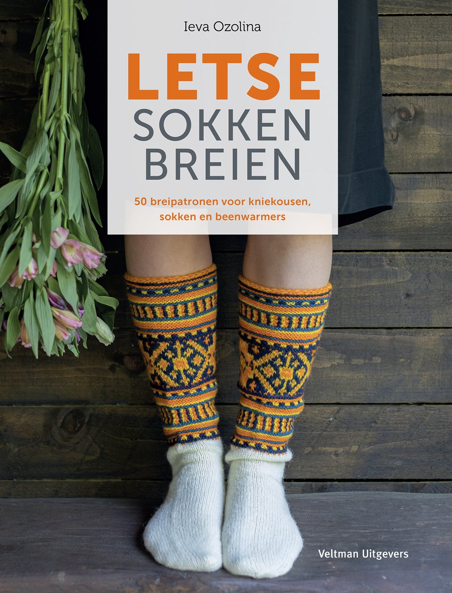 Witte sokken met kniekousen met oranje en blauwe Letse patronen.