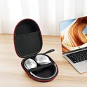 Zwarte YONO koptelefoonhoes met rode rits, open met zilverkleurige koptelefoon, naast een open laptop.