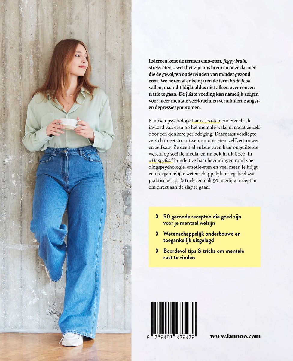 Vrouw met lange blonde haren, gekleed in een lichtgroene blouse en wijde jeans, houdt een kopje vast.
