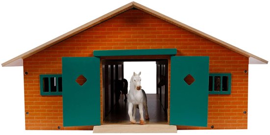 Houten paardenstal met oranje bakstenen façade, grote groene dubbele deuren, witte paard in deuropening.