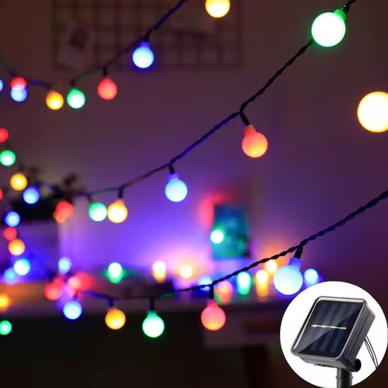 Guirlande de lumières colorées en boules avec panneau solaire sur un mur.