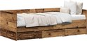 Bedbank in verweerd hout, opgemaakt met beddengoed en kussens, met gesloten lades.