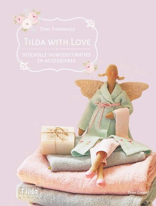 Een Tilda engelpop met vleugels, gekleed in een mintgroene jas met roze strik en gestreepte broek, zittend op een stapel zachte roze en mintgroene handdoeken.