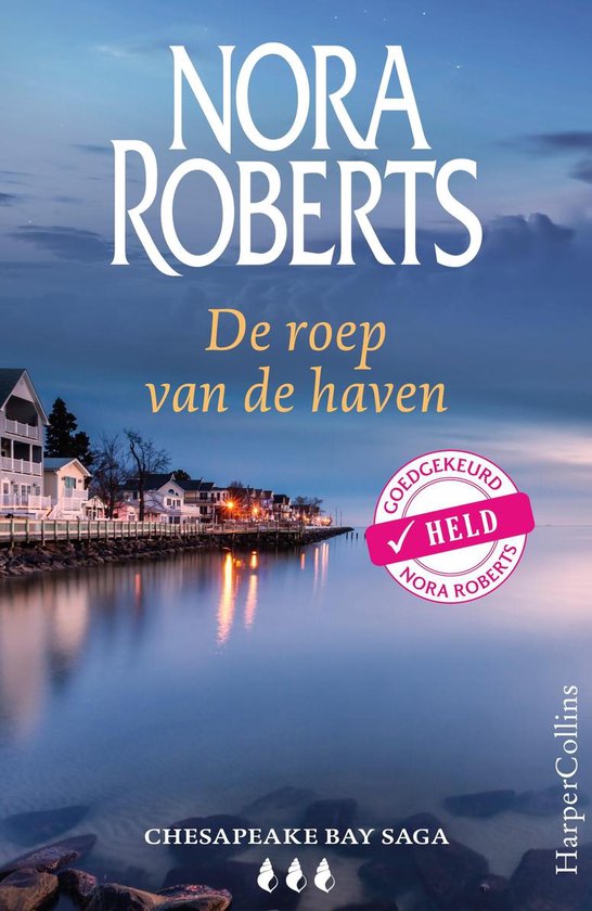 Boekomslag 'De roep van de haven' met een dorp aan de kust bij zonsondergang. Tekst 'Nora Roberts' en 'Chesapeake Bay Saga'.